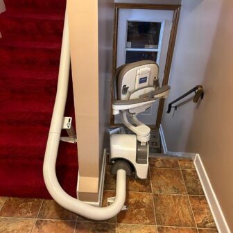 A Curved Stairlift Along The Inside Above A Red Carpet